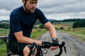 Cycliste sur route consultant sa montre GPS au guidon de son vélo de route en milieu rural